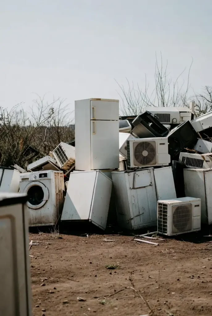 “Multiple white goods including fridges, washing machines, and air conditioners stacked for disposal”