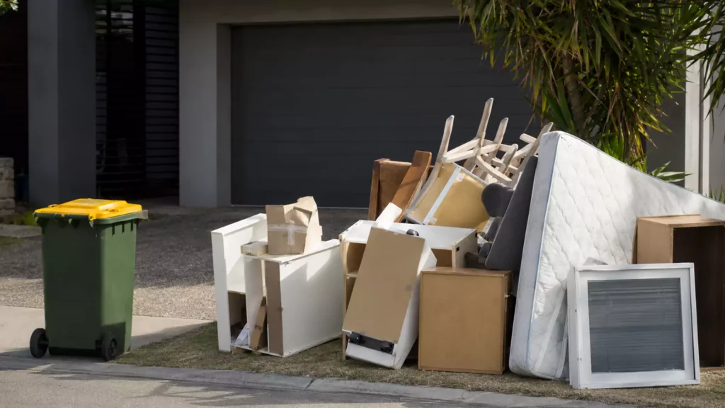 Bulky household rubbish and unwanted furniture piled outside a suburban rental property for removal